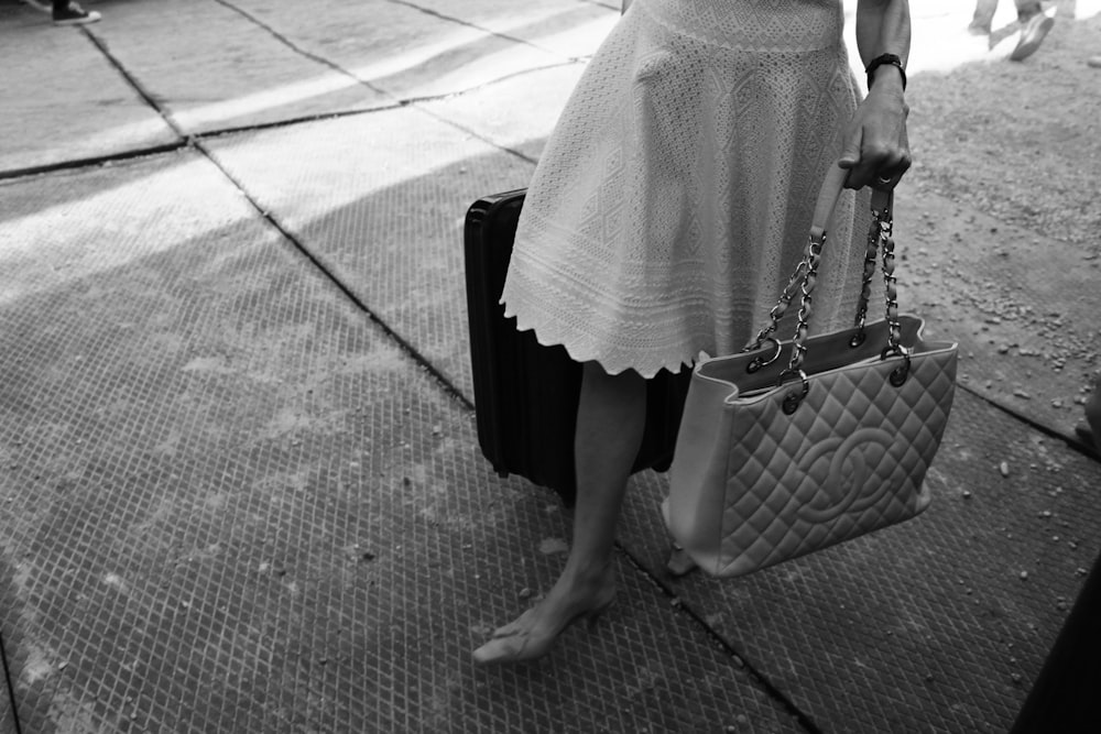 a woman in a white dress holding a handbag
