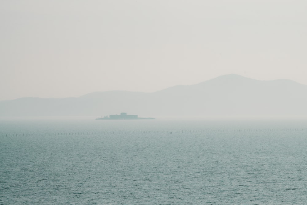 a large body of water with a boat in the distance