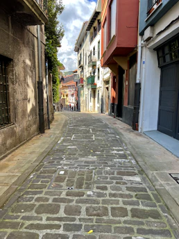 A cozy street in Calabria lined with small shops and colorful storefronts under warm sunlight.