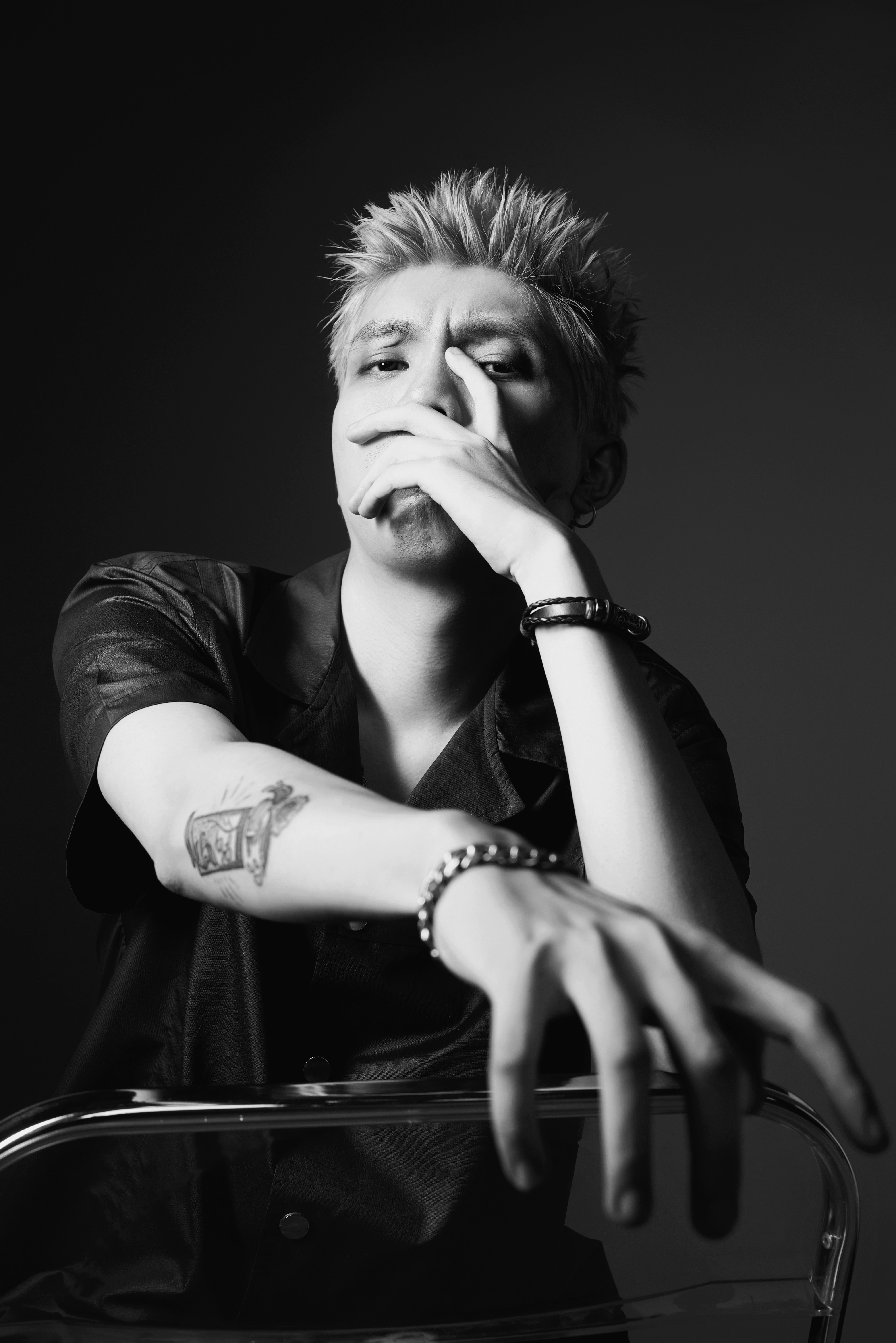 a black and white photo of a man with his hand on his face