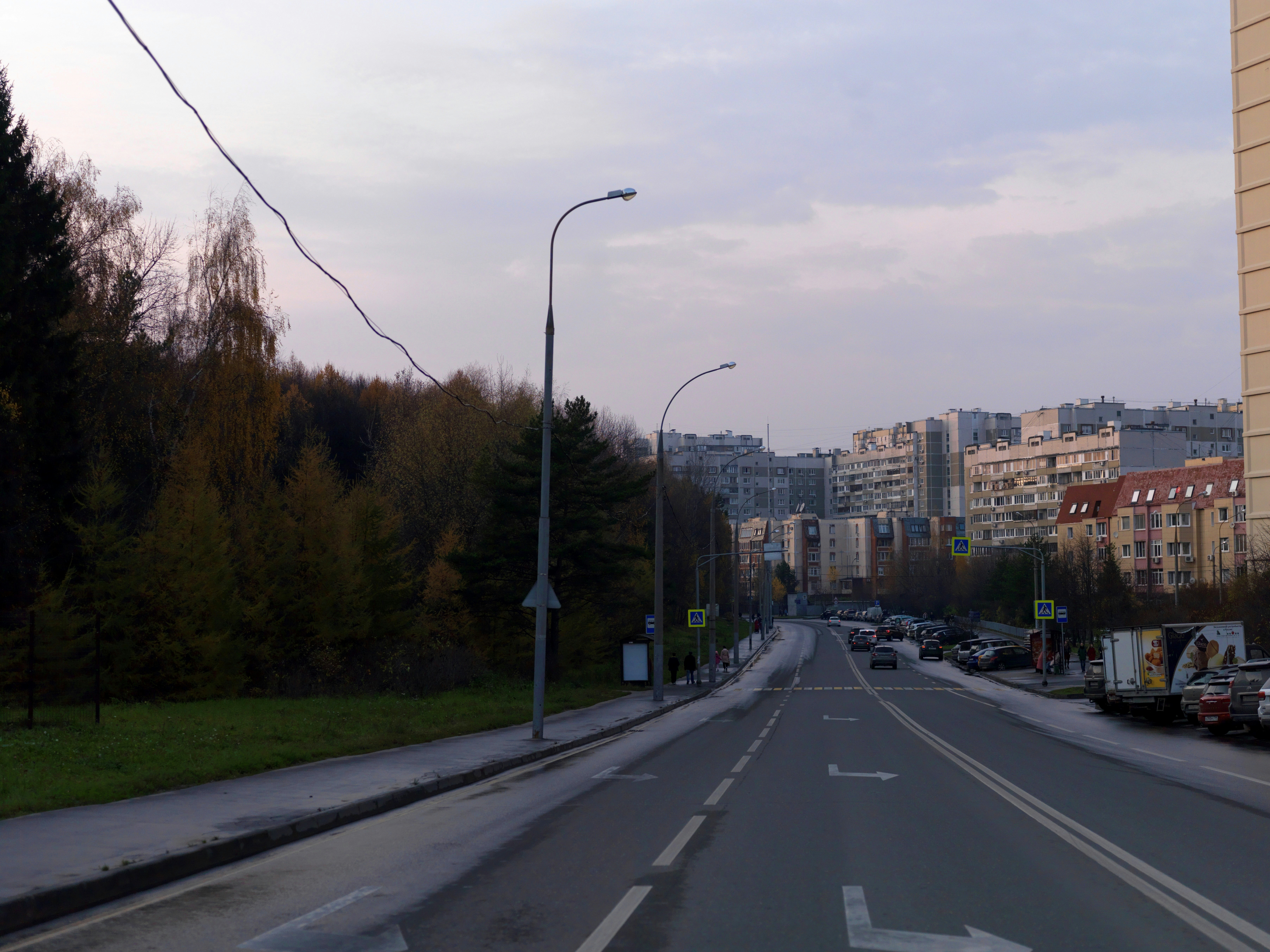 A street lined with parked cars and tall buildings