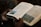 A person is holding an open book with text and colorful images on the pages. The book appears to be a religious or spiritual text, as indicated by the chapter title 'PETER'. The person is gripping the book gently with both hands.