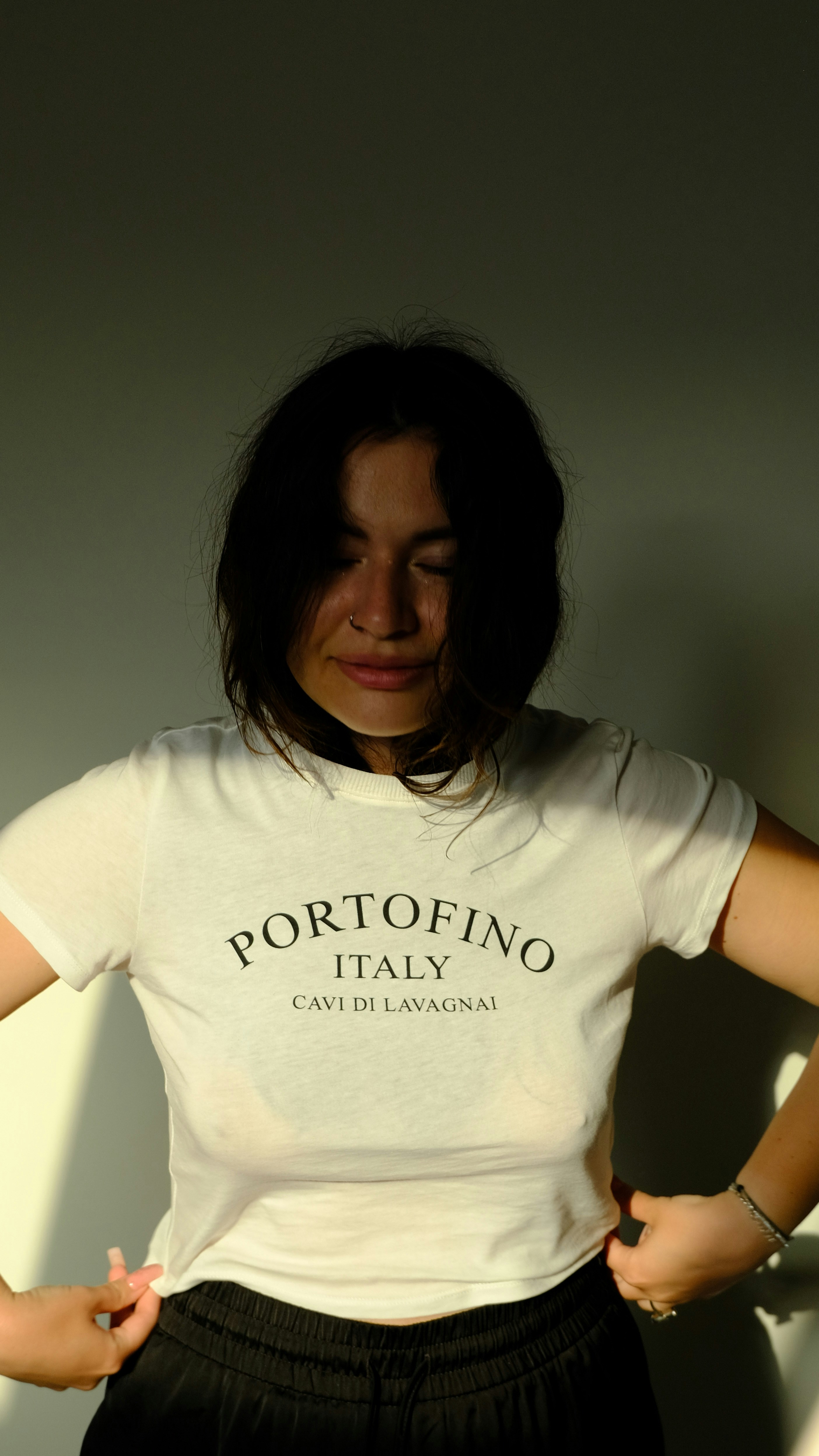 a woman standing in front of a white wall