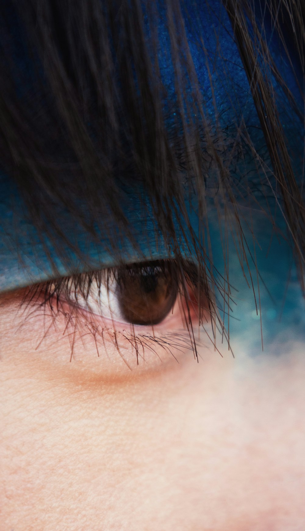 a close up of a person's eye with blue makeup