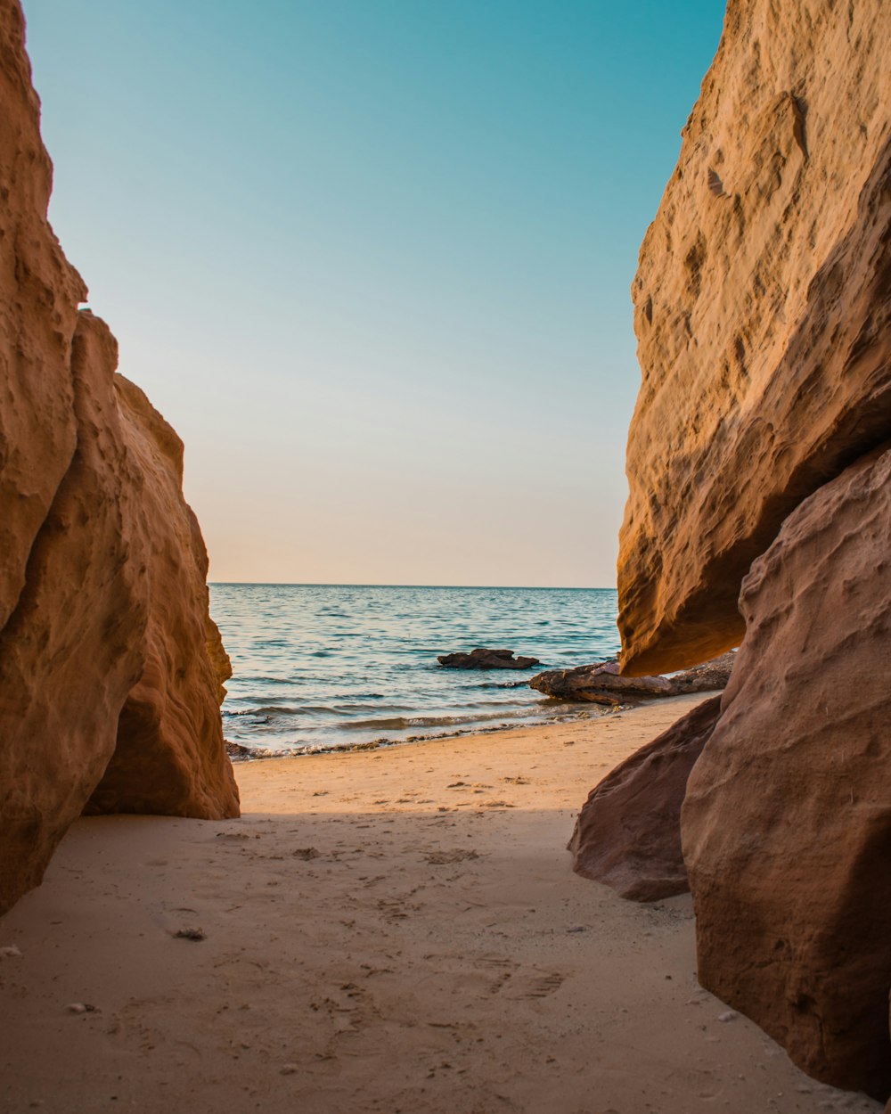 a view of the ocean through two large rocks