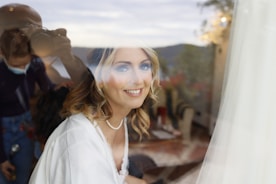An elegant young woman smiling gently in a soft-lit room.