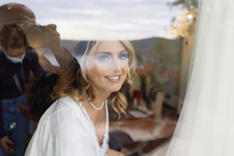 An elegant young woman smiling gently in a soft-lit room.