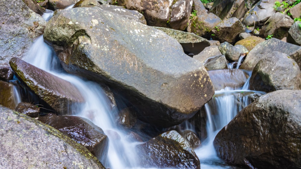 a close up of a small waterfall with rocks