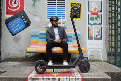 a man sitting on a bench next to a scooter