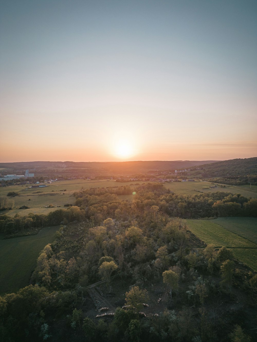 the sun is setting over a green field