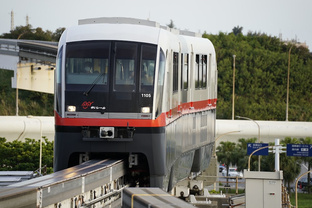 a train traveling down tracks next to a lush green hillside