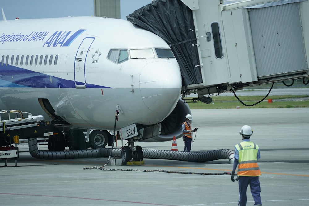 Un hombre parado junto a un avión en la pista