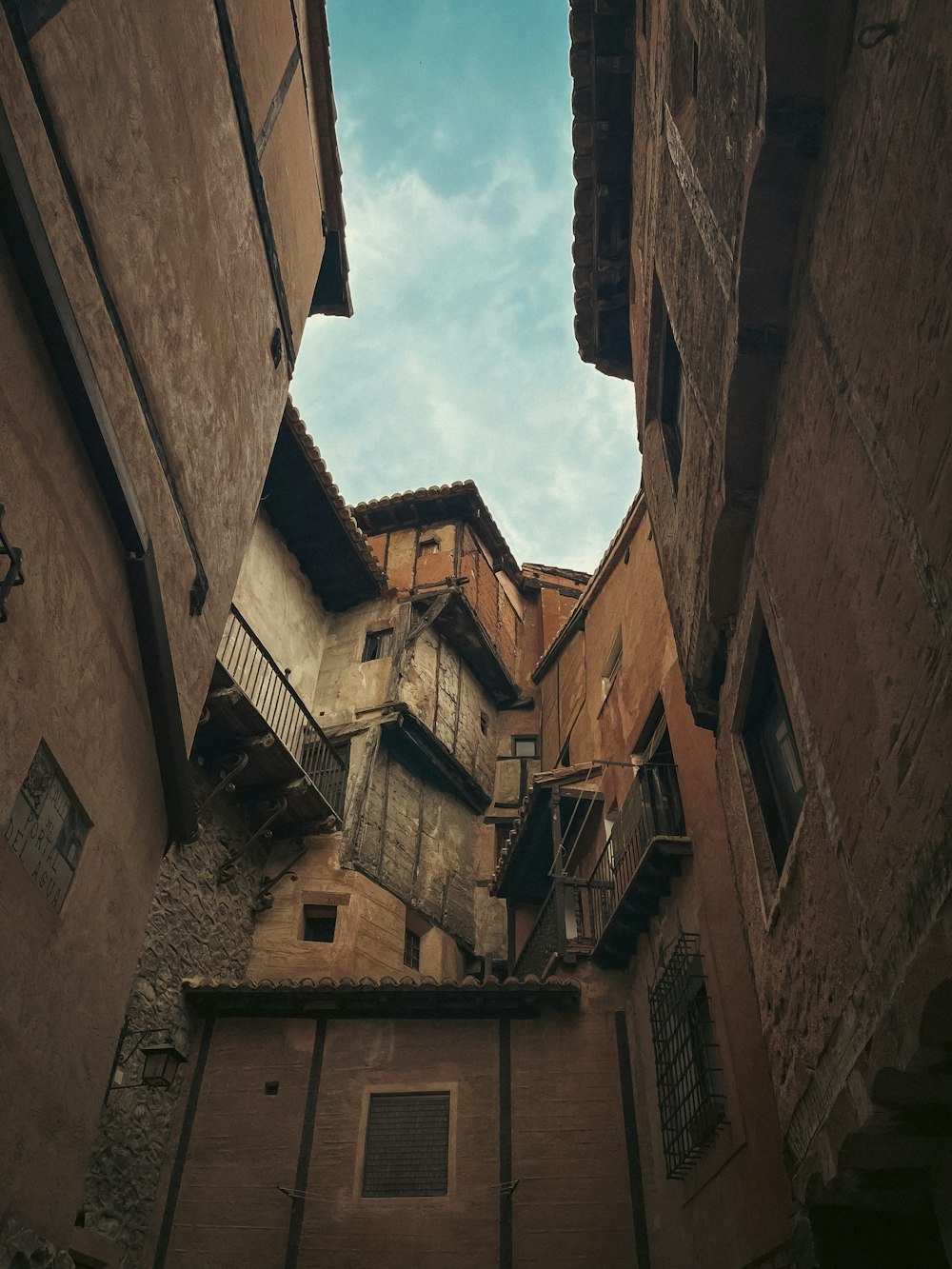 a narrow alley way with old buildings and a sky background