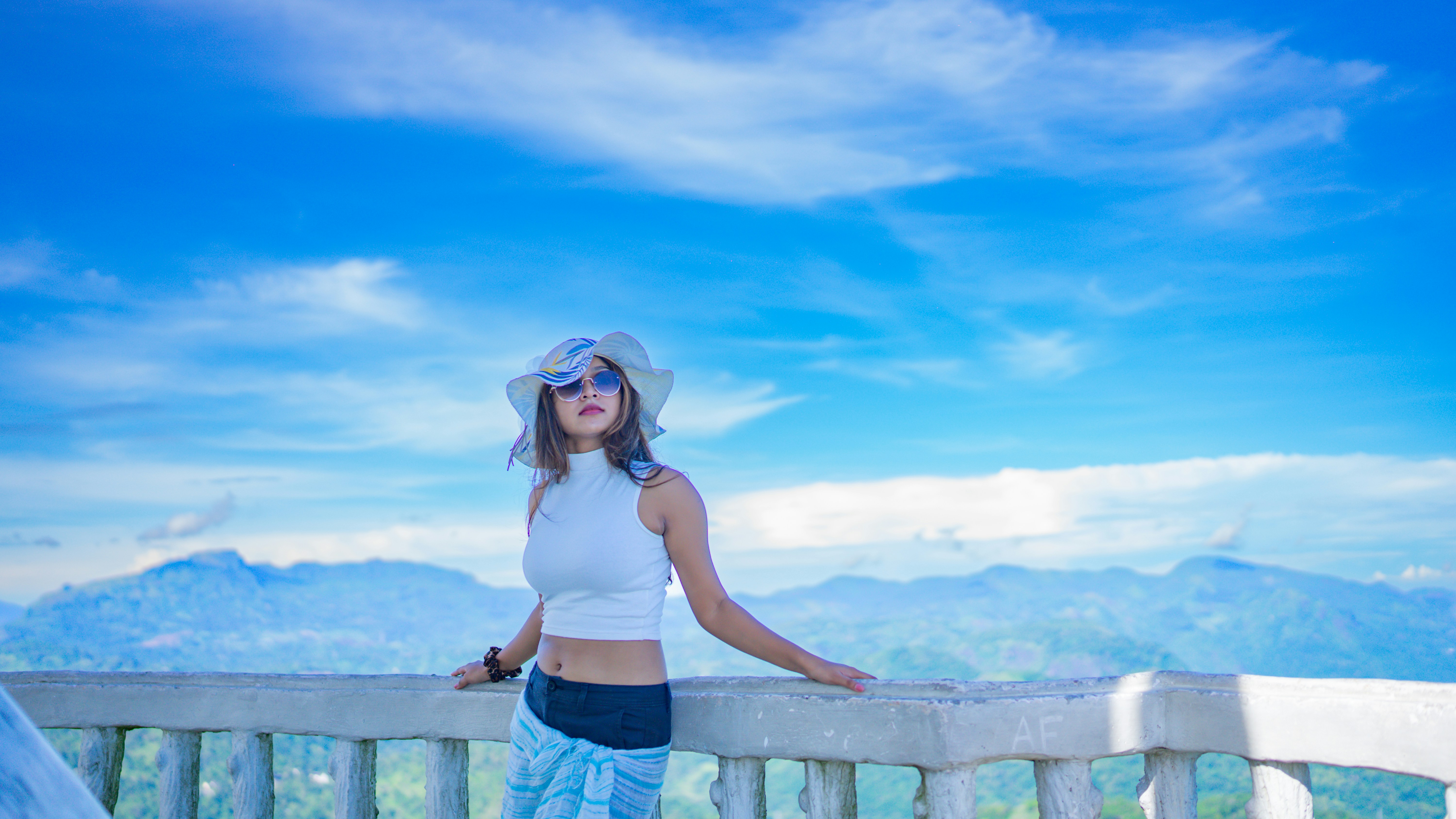 a woman standing on top of a wooden fence