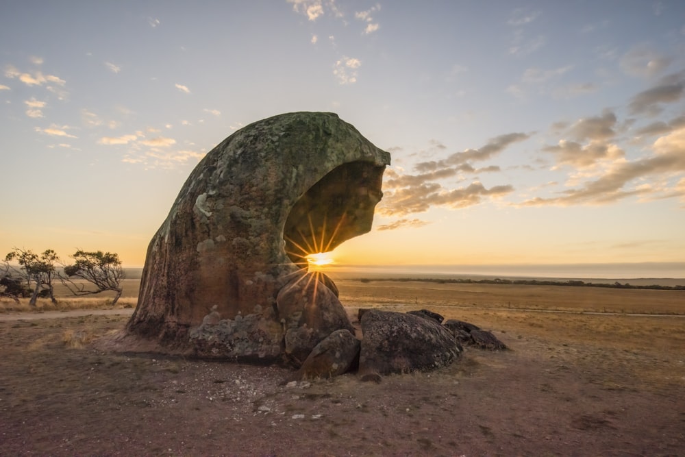 a large rock in the middle of a field