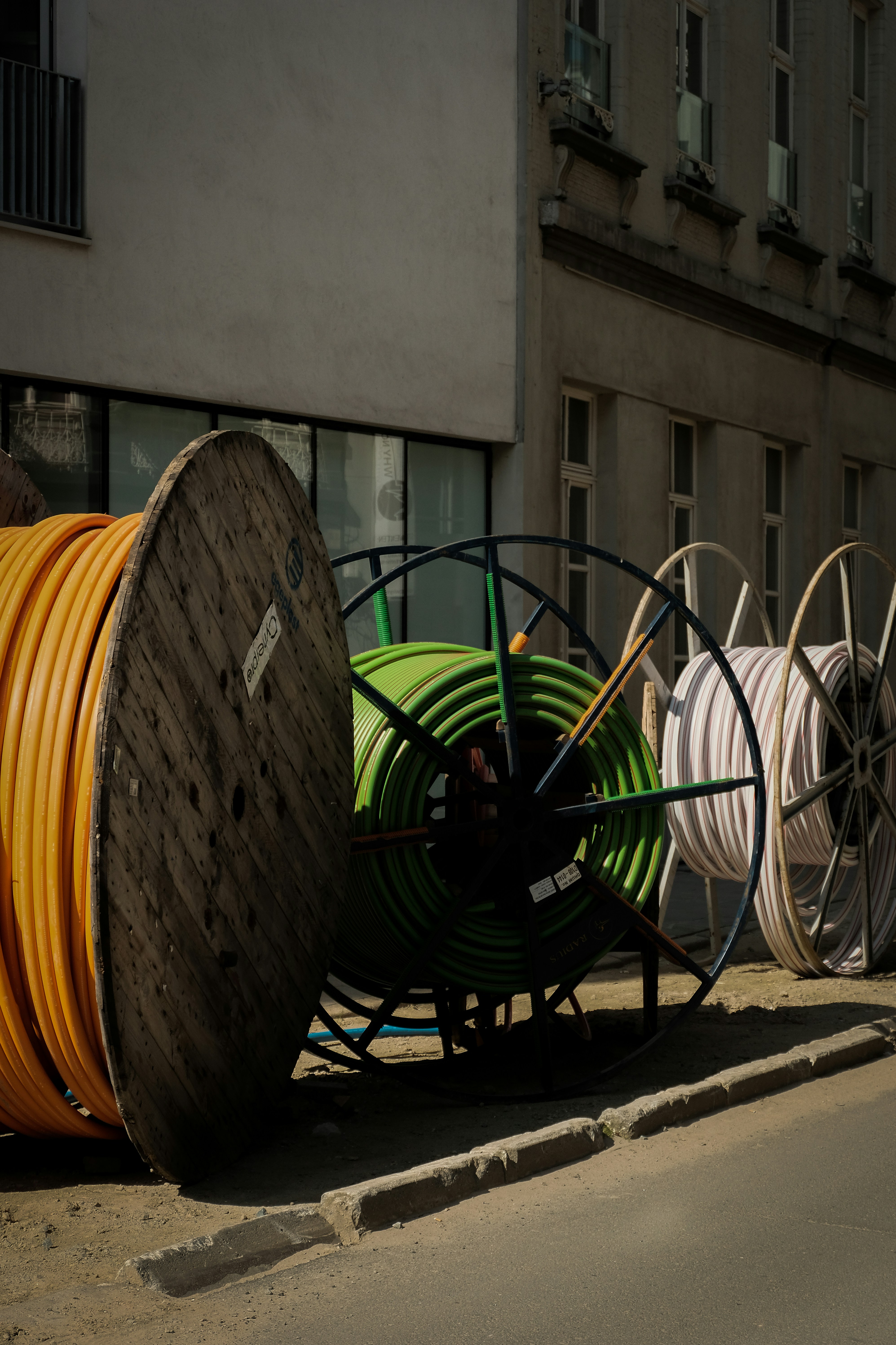 a pile of yellow and green hoses sitting on the side of a road