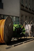 a pile of yellow and green hoses sitting on the side of a road