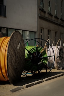 a pile of yellow and green hoses sitting on the side of a road