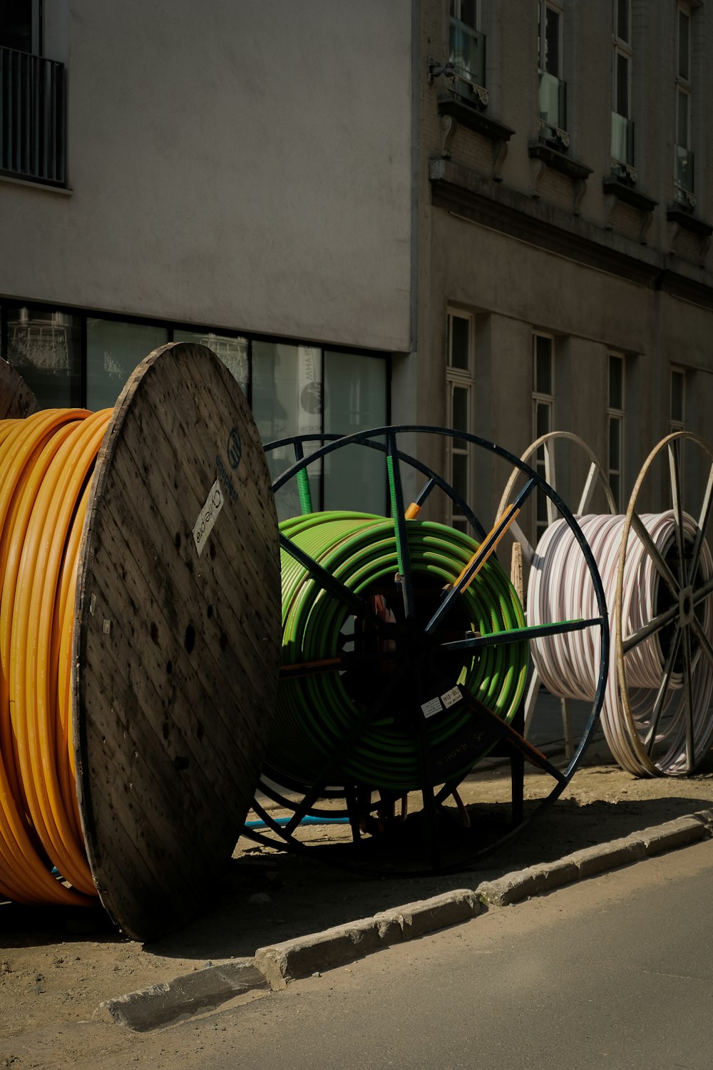 a pile of yellow and green hoses sitting on the side of a road