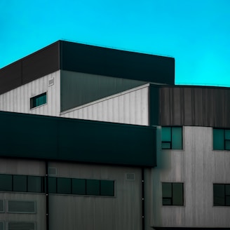A modern industrial zone with turquoise accents under a clear sky.