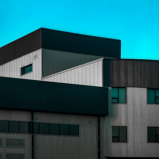 A modern industrial zone with turquoise accents under a clear sky.
