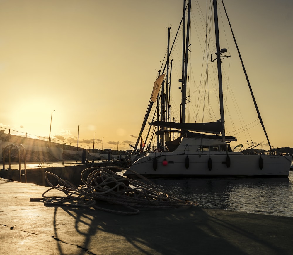 a sailboat docked in a harbor at sunset