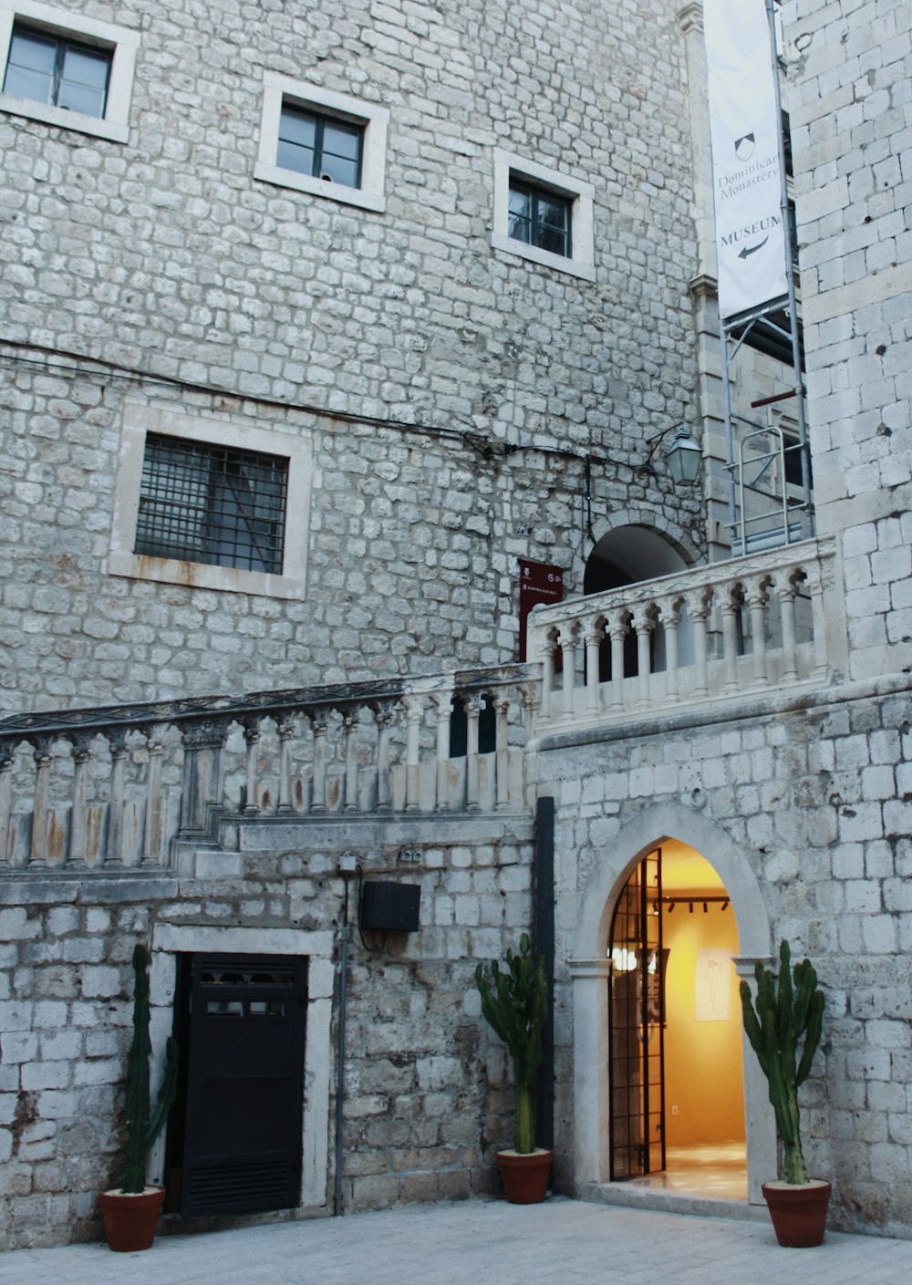 a stone building with a door and a balcony