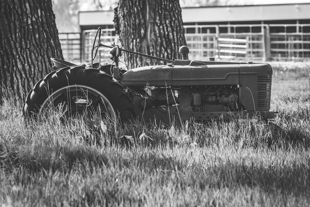 a black and white photo of an old tractor in a field