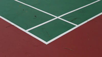 A sports court mid-cleaning, showing a sharp contrast between cleaned and dirty surfaces.