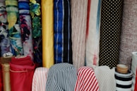 Various rolls of decorative fabrics displayed in a retail store setting.