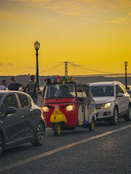 Happy tourists enjoying a sunset ride in a tuk-tuk with Madrid skyline in the background.