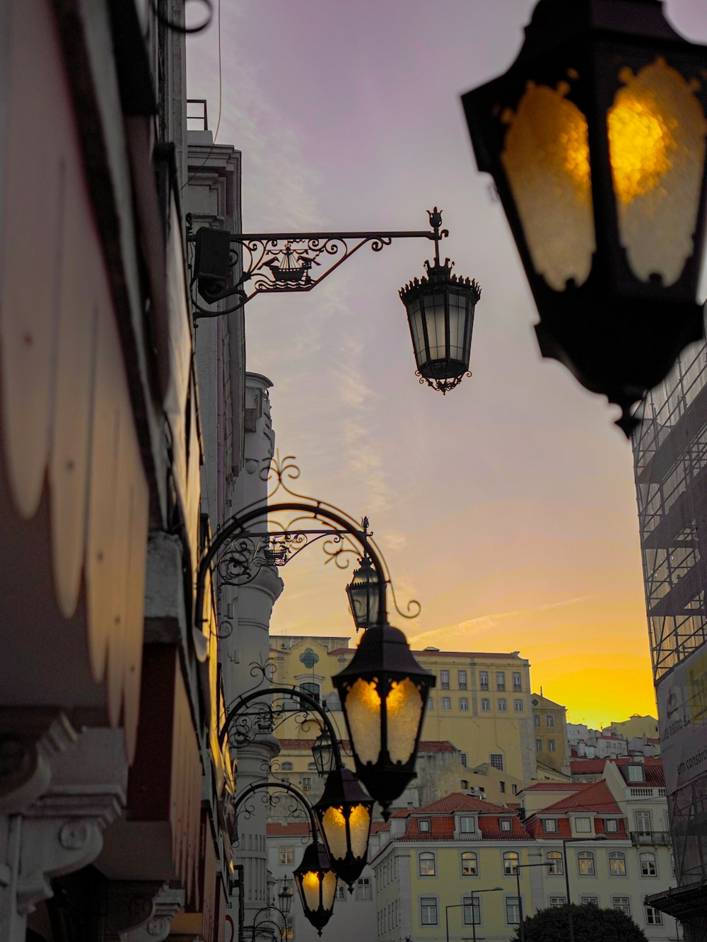 a couple of street lights hanging from the side of a building