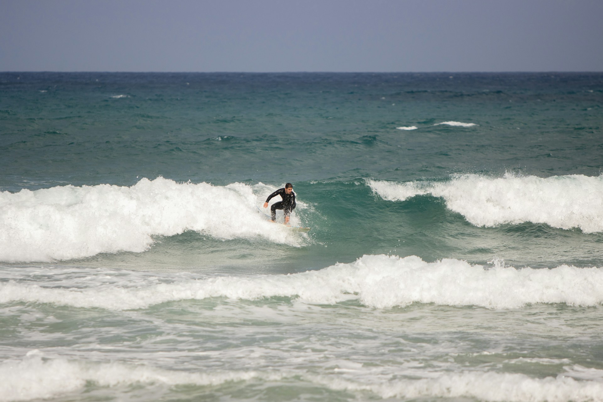 a man riding a wave on top of a surfboard