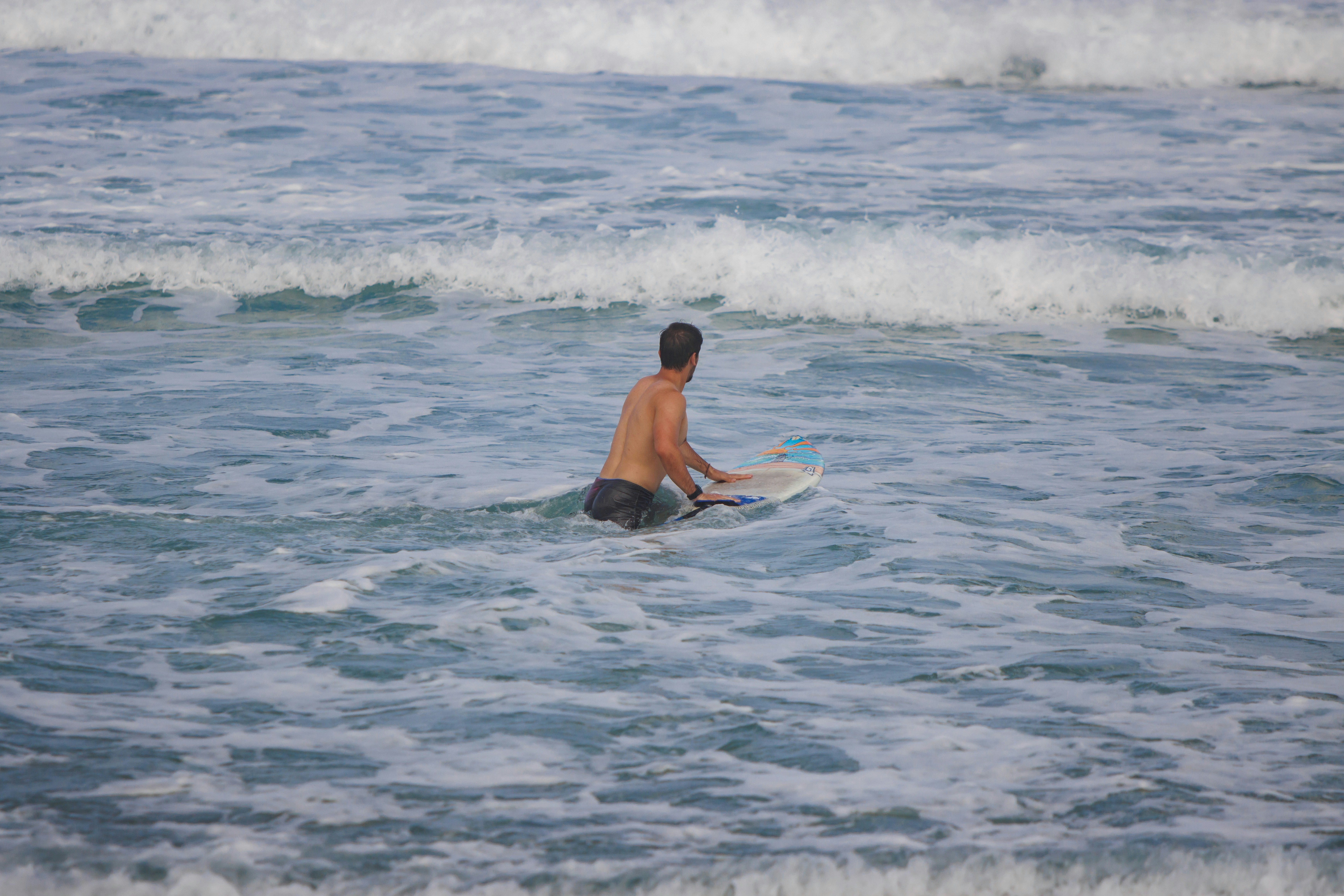 A man riding a surfboard on top of a wave in the ocean photo – Free Man ...