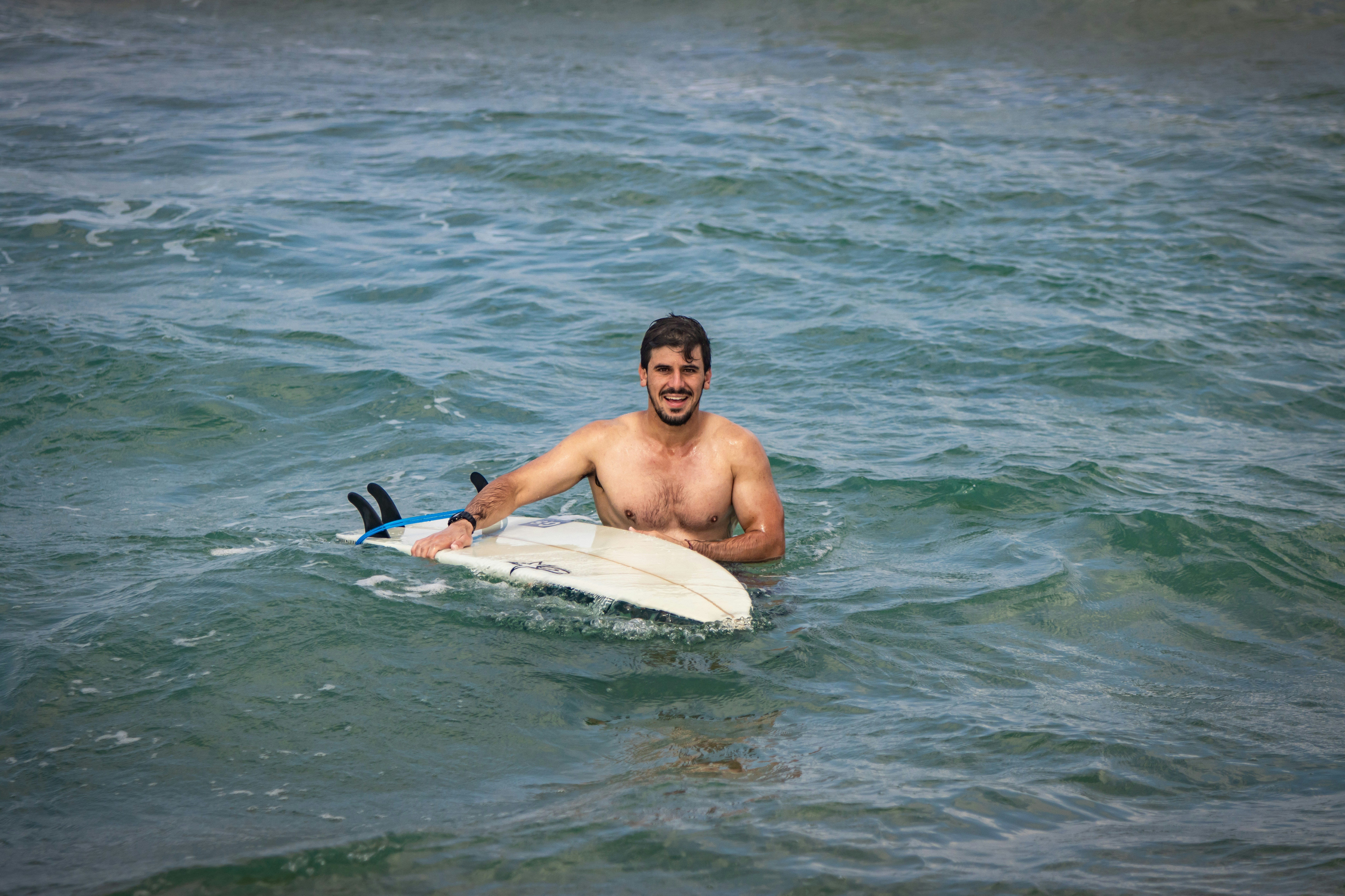 A man riding on top of a surfboard in the ocean photo – Free Man Image ...