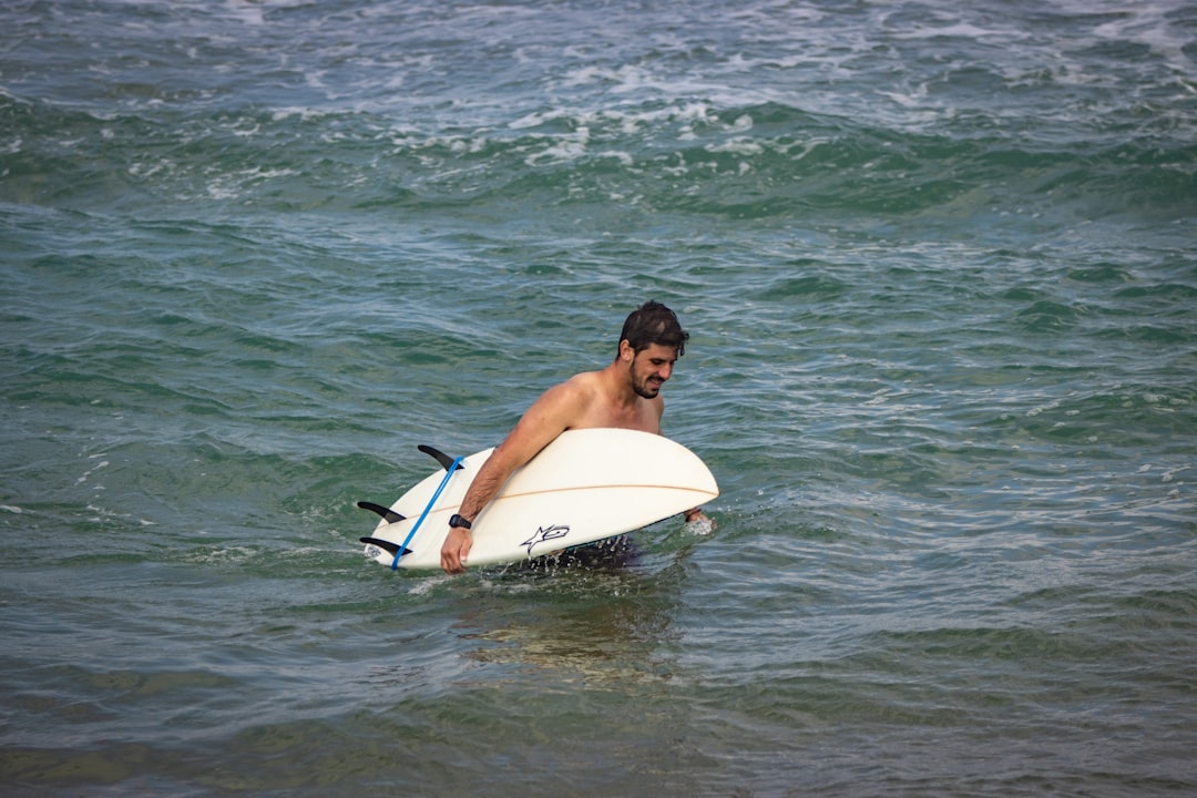 a man holding a surfboard in the ocean,