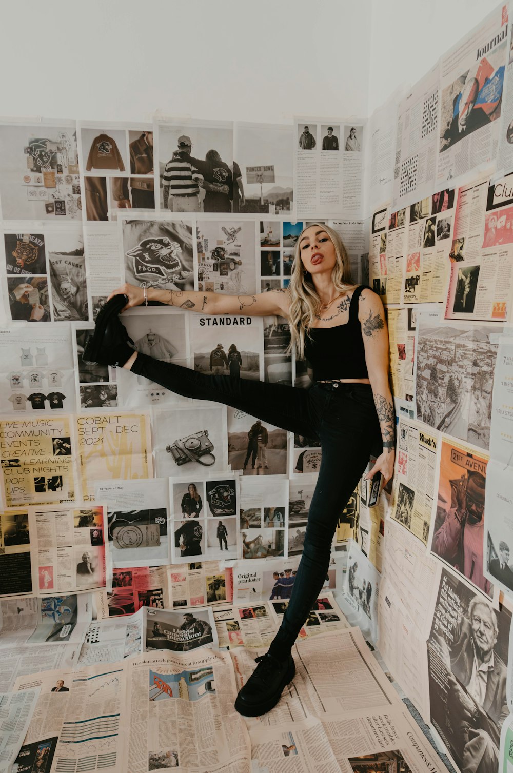 a woman standing on top of a pile of newspapers