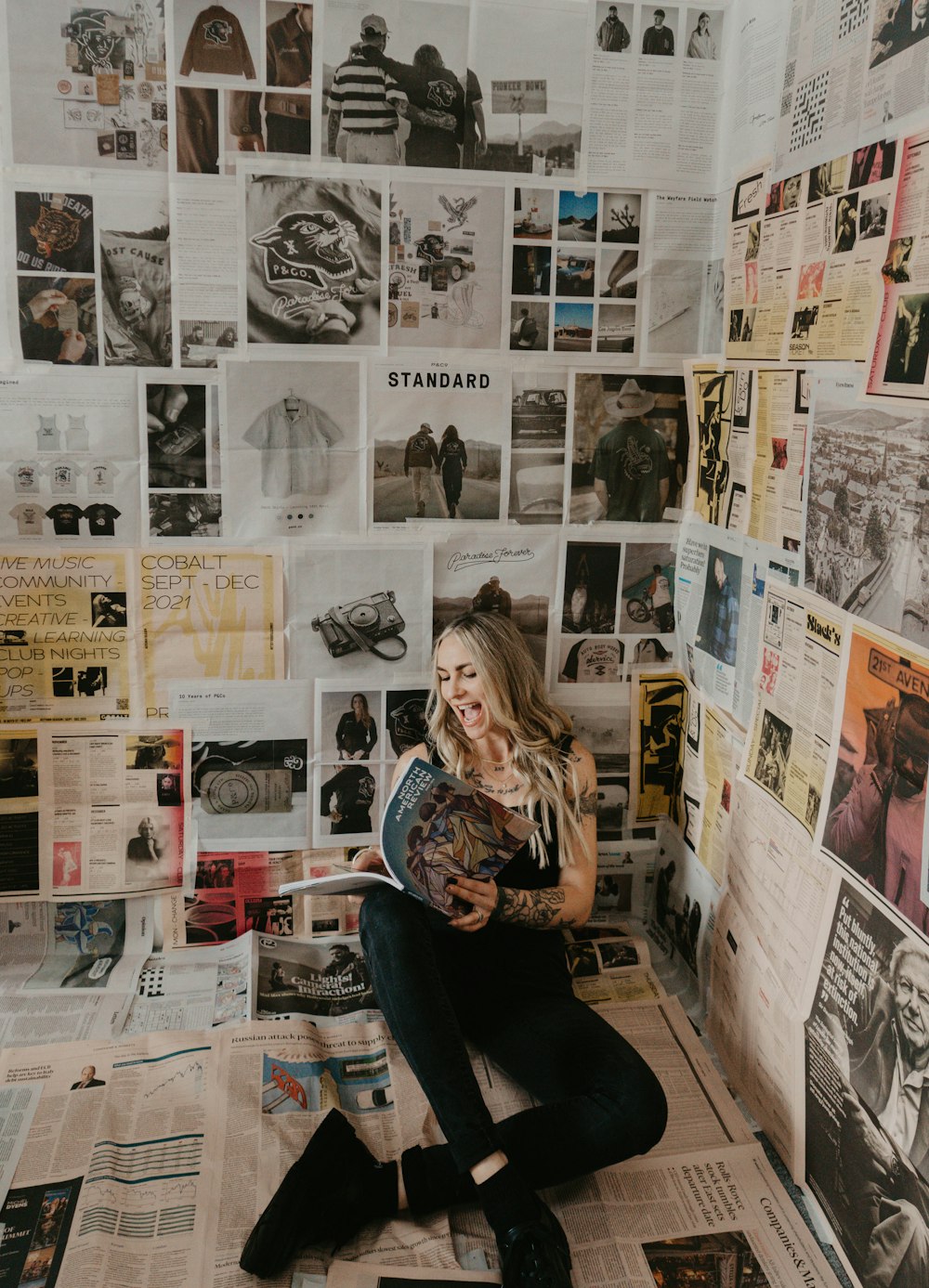 a woman sitting on the floor reading a book