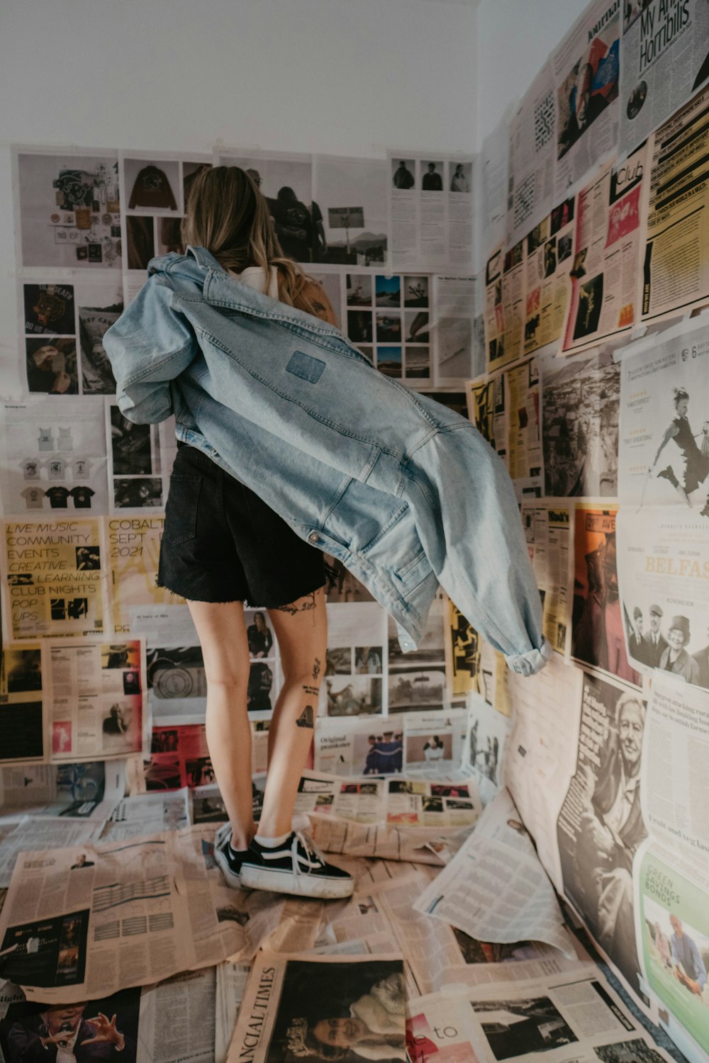 a woman standing on top of a pile of newspapers