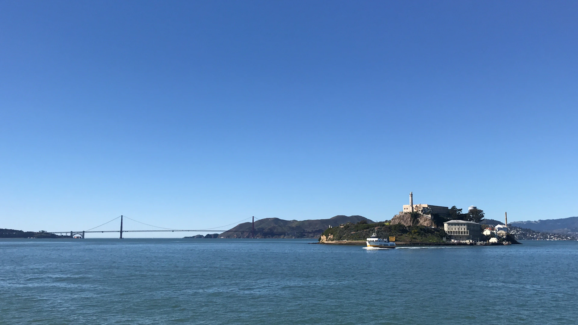 A misty view of Alcatraz Island with the prison looming under a cloudy sky, evoking the mystery of the escapes.