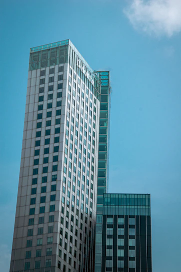 A sleek, ultramodern residential building under construction with steel and glass elements reflecting the sky.