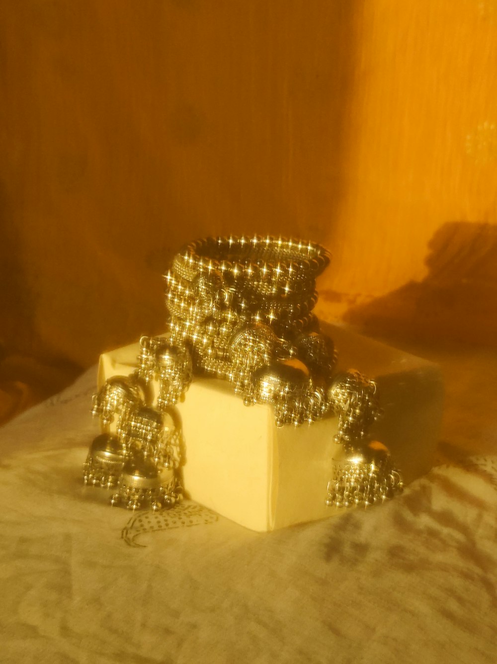 a stack of silver balls sitting on top of a white box