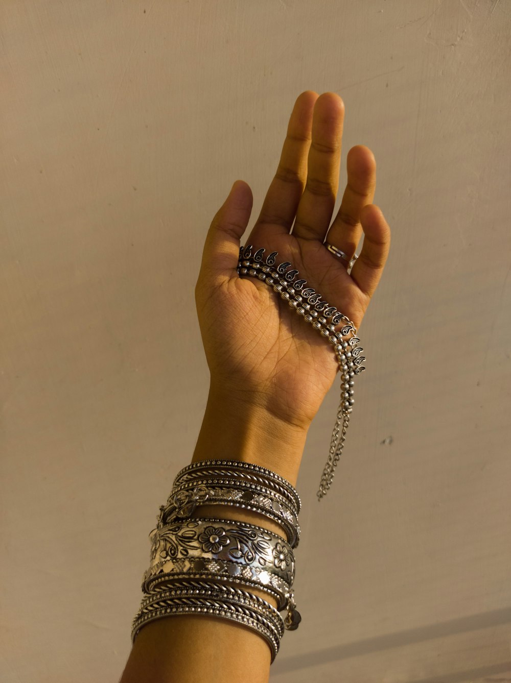 a woman's hand holding a bunch of bracelets