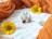 A close-up of delicate white flower earrings displayed on a soft fabric background.
