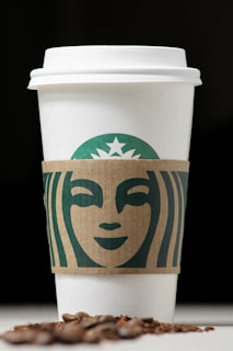 A warm, earthy-toned logo design featuring green mocha and cream hues with natural textures.