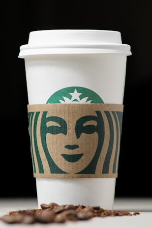 A warm, earthy-toned logo design featuring green mocha and cream hues with natural textures.