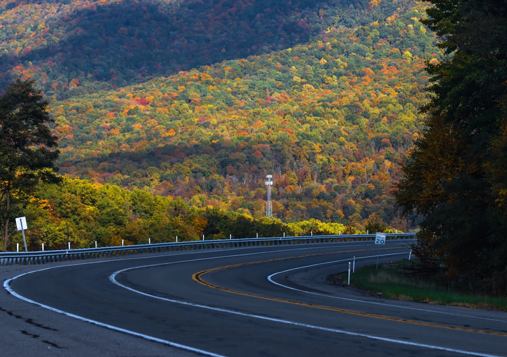 a curve in the road in front of a mountain