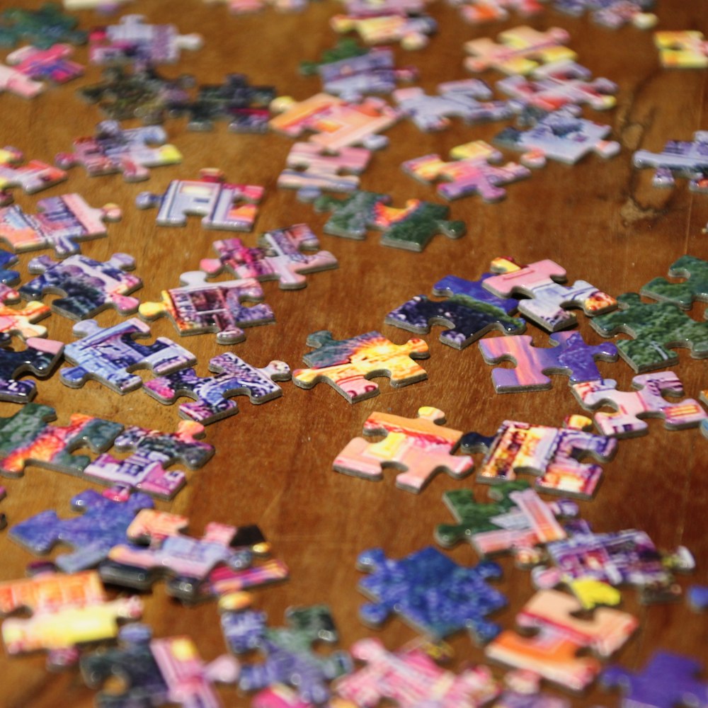a wooden table topped with lots of puzzle pieces