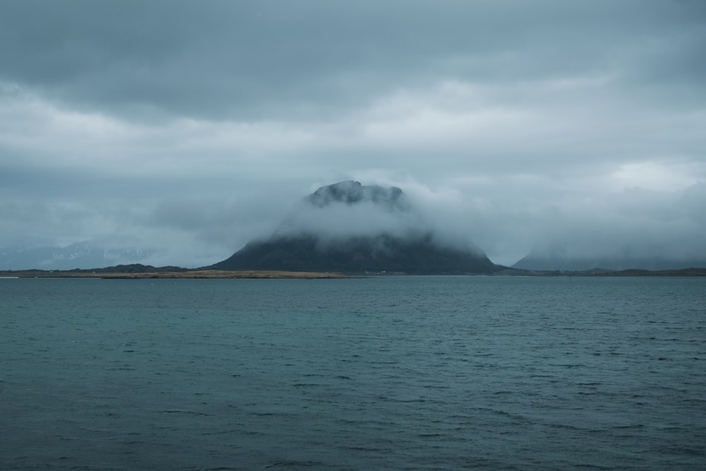 a large body of water with a mountain in the background