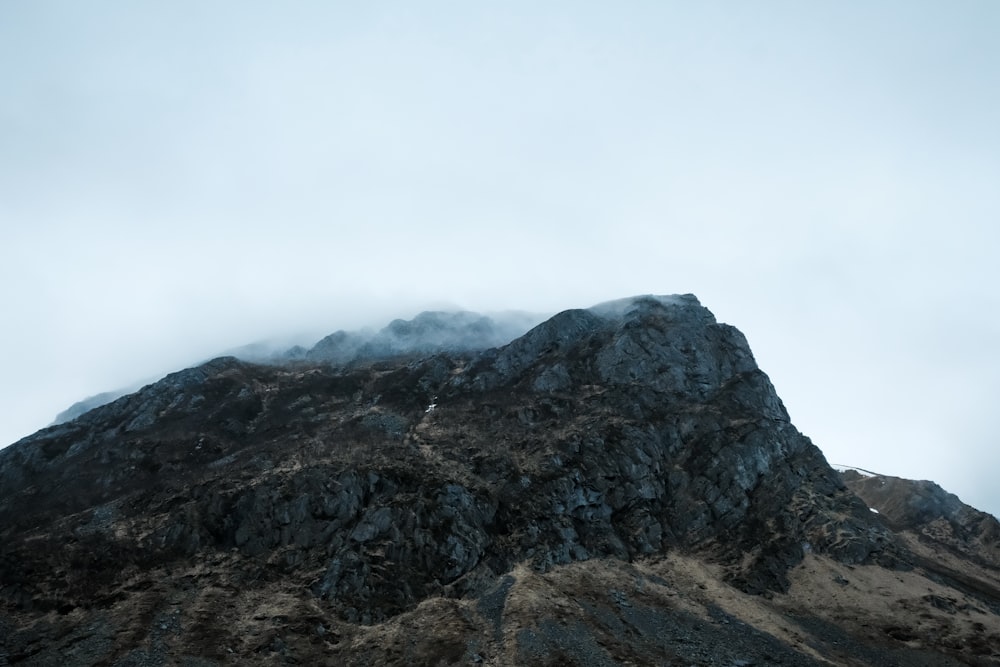 a very tall mountain with some clouds in the sky